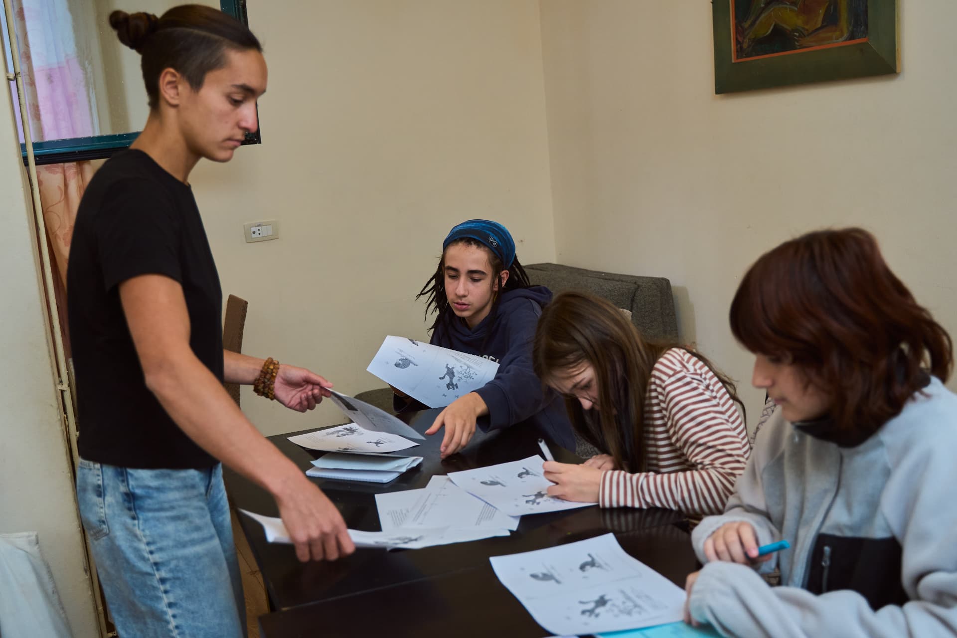 Преподаватель раздаёт ученикам рабочие листы